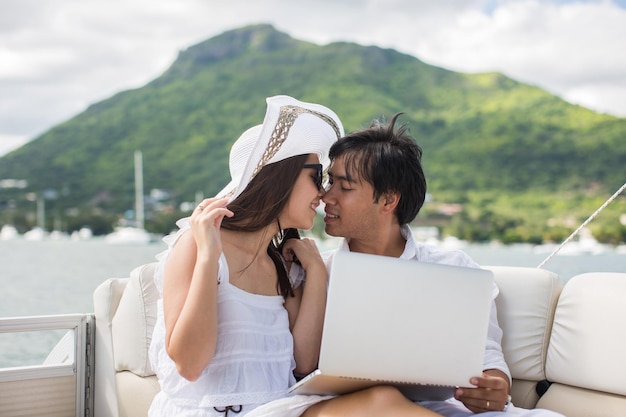 Two business people working with laptop on a sailing boat  sailing trip