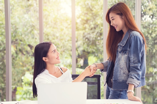 Two business women shaking hands,Business collaboration Concepts.