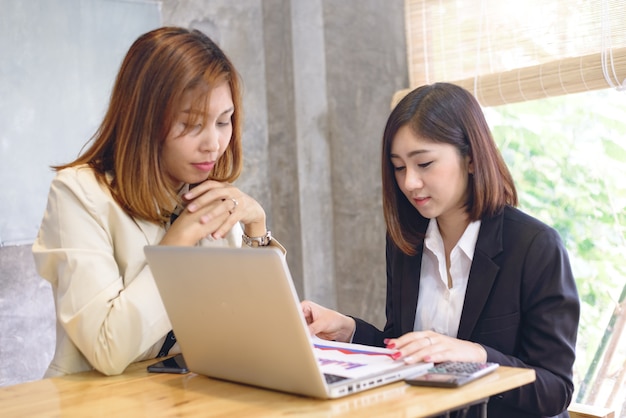 two business women working with laptop in office.Workplace strategy Concept.