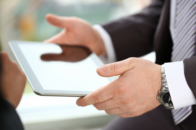 Two businessman are using a digital tablet