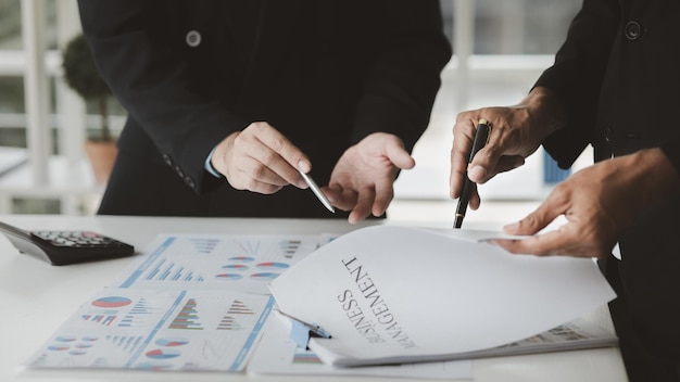 Two businessmen are brainstorming together and reviewing the company financial documents that the finance department has summarized they are business partners Business administration concept