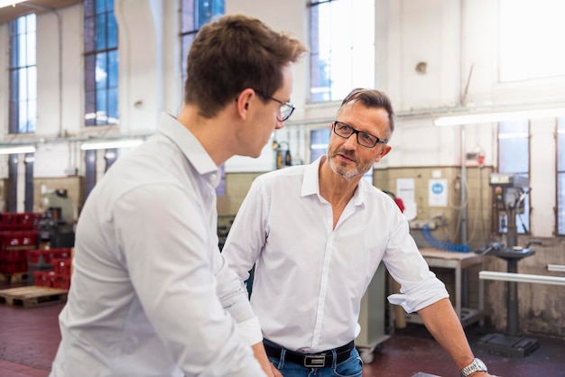 Two businessmen discussing in factory