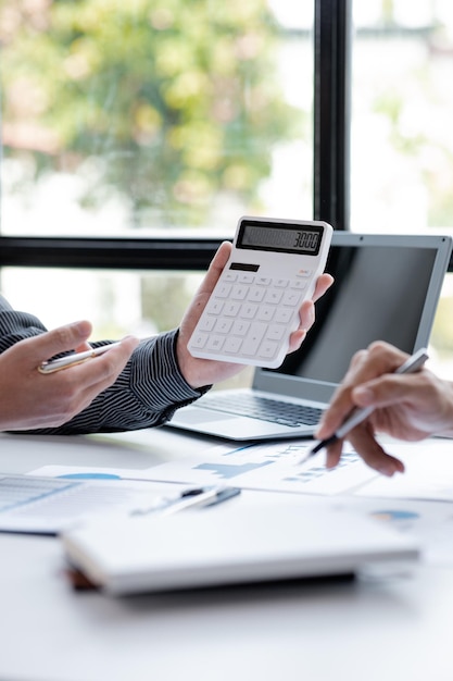 Two businessmen looking at sales data sheets in the office they are business partners forming a startup company are having a brainstorming meeting and planning an administration together