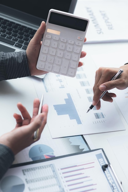 Two businessmen looking at sales data sheets in the office they are business partners forming a startup company are having a brainstorming meeting and planning an administration together