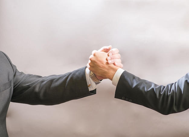 Two businessmen partner to greet each other a firm handshake