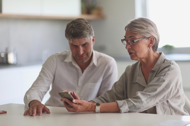 Two businessmen at the table looking at the phone