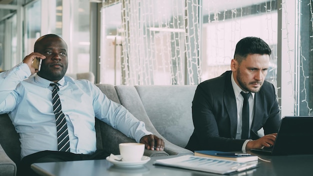 Two businessmen working in cafe