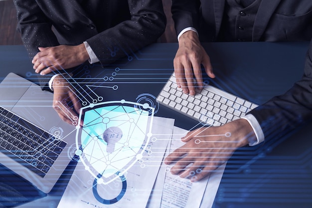 Two businesspeople man and woman working on the project to protect cyber security of international company Padlock Hologram icons over the table with documents Formal wear Workspace