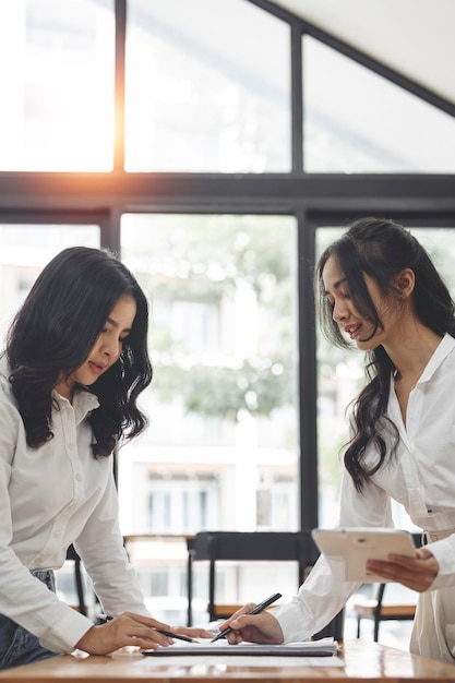 Two businesswoman working discussing business plan and strategy at office desk Business casual meeting