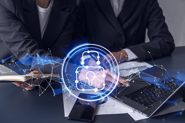 Two businesswomen working on the project to protect cyber security of international company Padlock Hologram icons over the table with documents