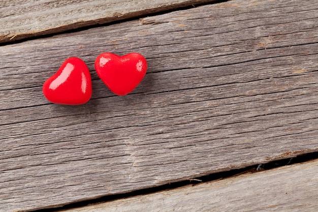 Two candy hearts over wood