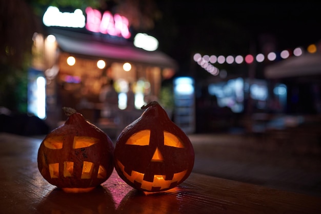 Two carved pumpkins during the halloween celebration at night in the city