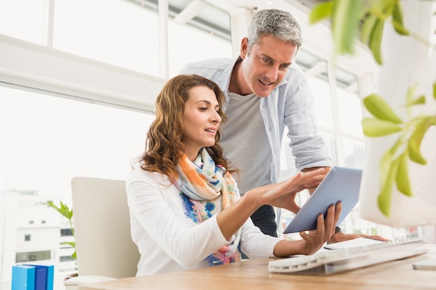 Two casual designers working with tablet in the office