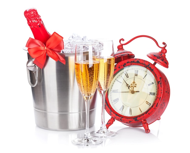 Two champagne glasses bottle in cooler and clock