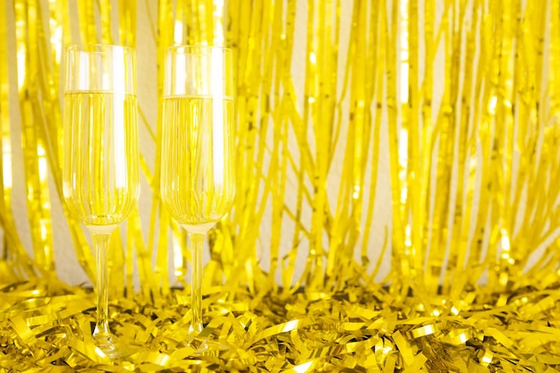 Two champagne glasses on the festive golden background.