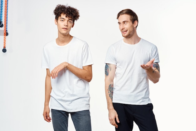 Photo two cheerful friends in white tshirts emotions positive light background high quality photo