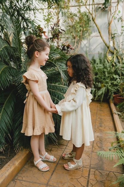 Two cheerful little girls in the botanical garden spring Summer