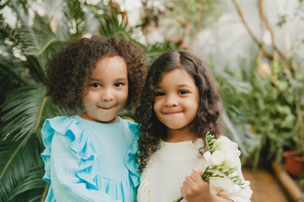 Two cheerful little girls in the botanical garden spring Summer