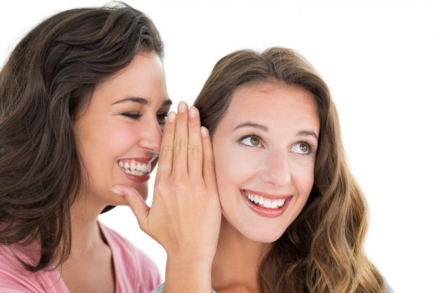 Two cheerful young female friends gossiping