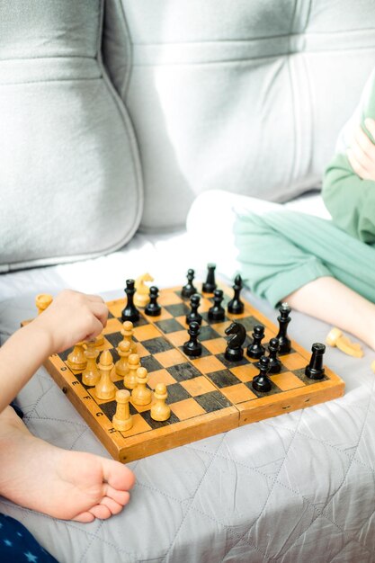 Two children are playing chess closeup Makes a knight and pawn move