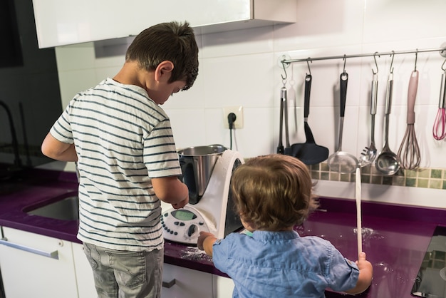 Two children baking cake at home.