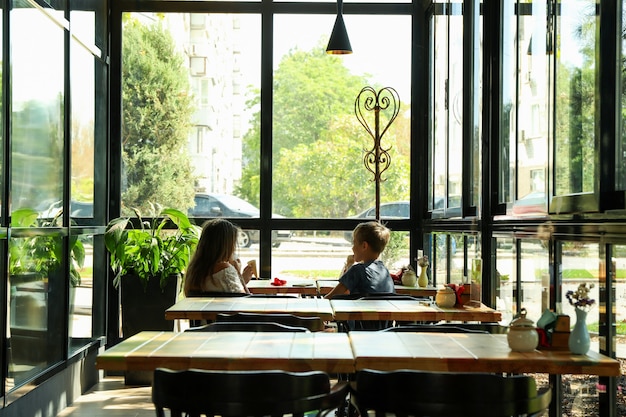 Two children eat ice cream in restaurant