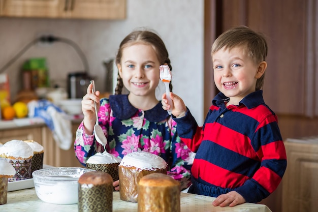 Two children a girl and a boy a brother and sister icing an Easter cake