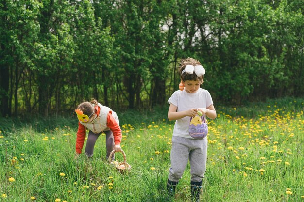 Photo two children hunt for easter eggs in a spring garden easter tradition