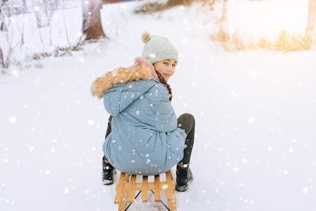 Two children ride on wooden retro sled on sunny winter day active winter outdoors games winter