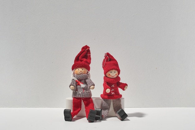 Photo two christmas elfs sitting together on white background. minimal christmas concept of love