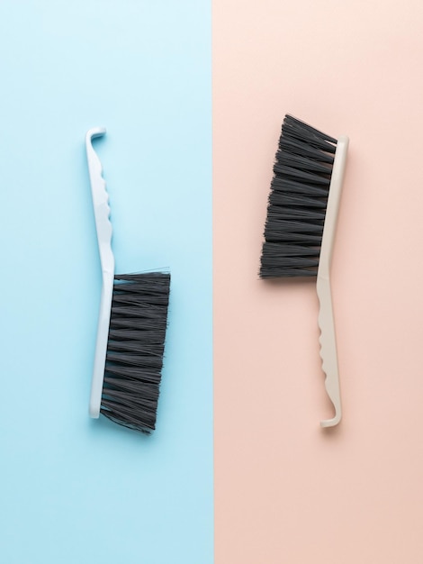 Two cleaning brushes on a twotone background Minimal concept of cleanliness guidance Flat lay