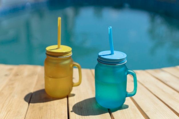 Two cocktails of yellow and blue standing by the pool Pool party outdoors