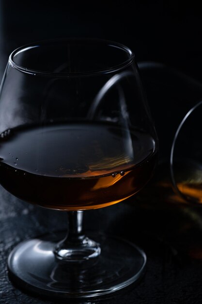 Two cognac glasses on a dark background