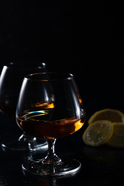 Two cognac glasses on a dark background