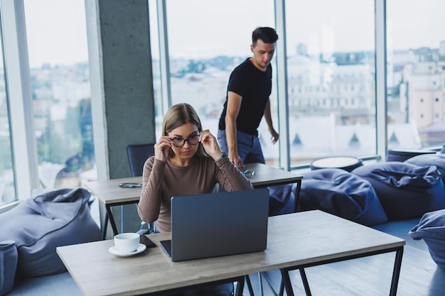 Two colleagues are discussing work on a laptop Friendly relations in the office between colleagues Workflow in the office