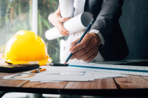 Two colleagues discussing data working and tablet laptop with on on architectural project at construction site at desk in office