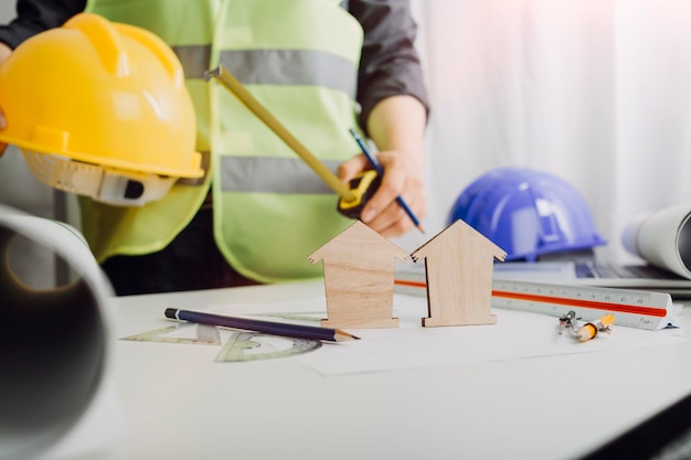 Two colleagues discussing data working and tablet laptop with on on architectural project at construction site at desk in office