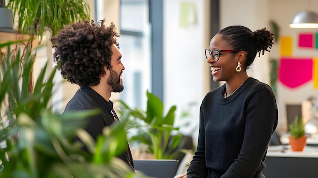 Two colleagues laughing and having a conversation in a modern office setting