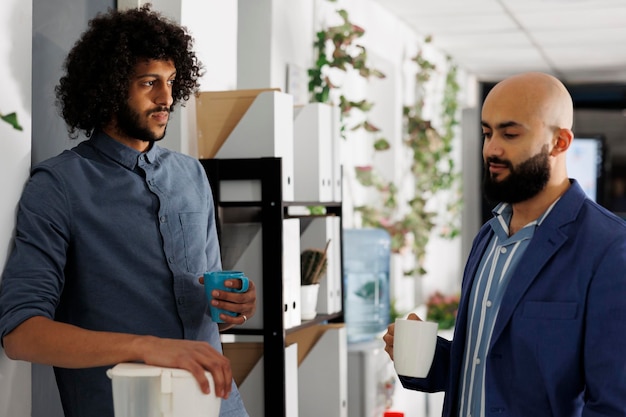 Two colleagues taking coffee break and chatting about work