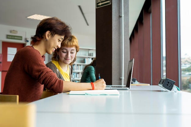 Two college students studying together in a library