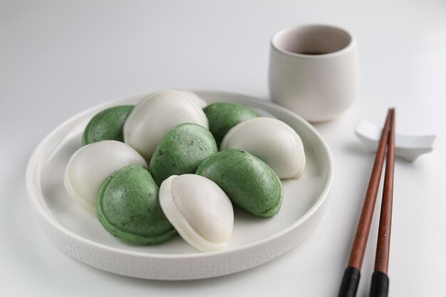 Two colors of Songpyeon halfmoonshaped rice cake Served in the white plate