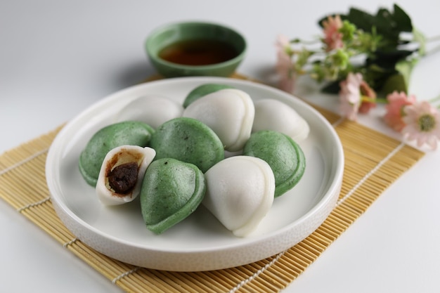 Two colors of Songpyeon halfmoonshaped rice cake Served in the white plate