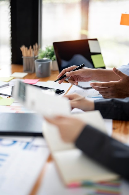 Two confident business people point to graphs and charts on tablet to analyze data balance sheet account and net profit