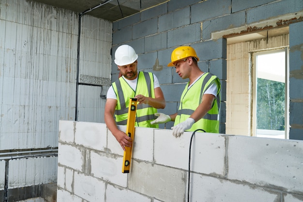 Two Construction Workers Building Wall