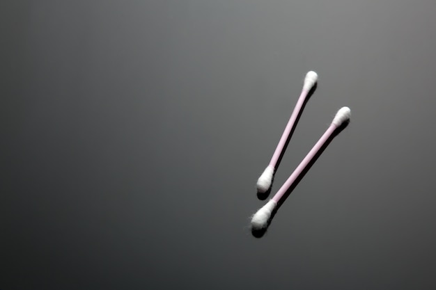 Two cotton buds isolated on black table