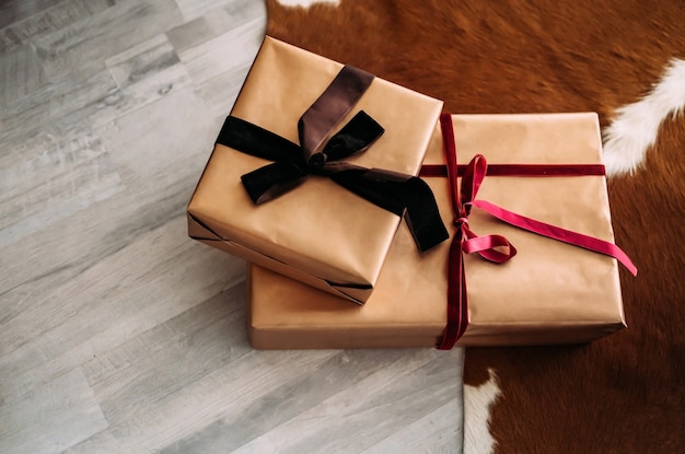 Two craft gift boxes lie on the floor near the carpet. Gift concept. Christmas mood.