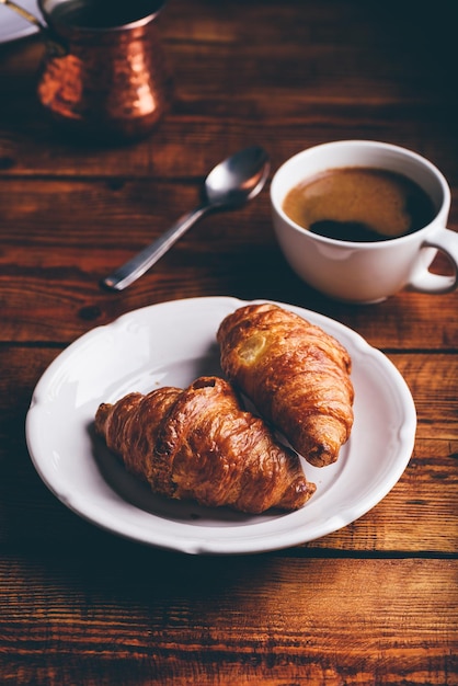 Two Croissants on White Plate and Cup of Black Coffee