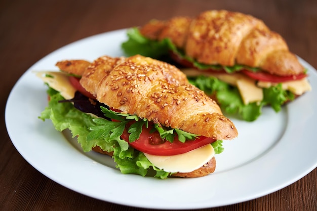 two croissants with tomatoes cheese and lettuce