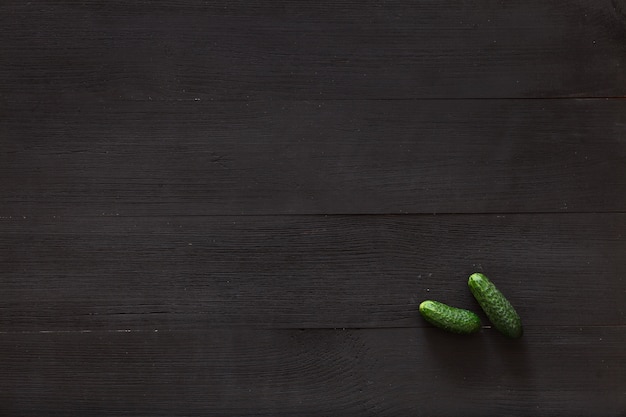 Two cucumbers on brown wooden background