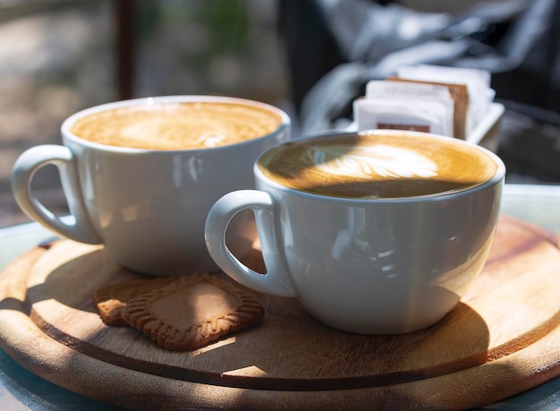 Two cup of espresso on wood table in the morning at direct sunlight What a great way to wake up Selective focus Inspirational early morning breakfast with coffee latte coffee cups on wood tray